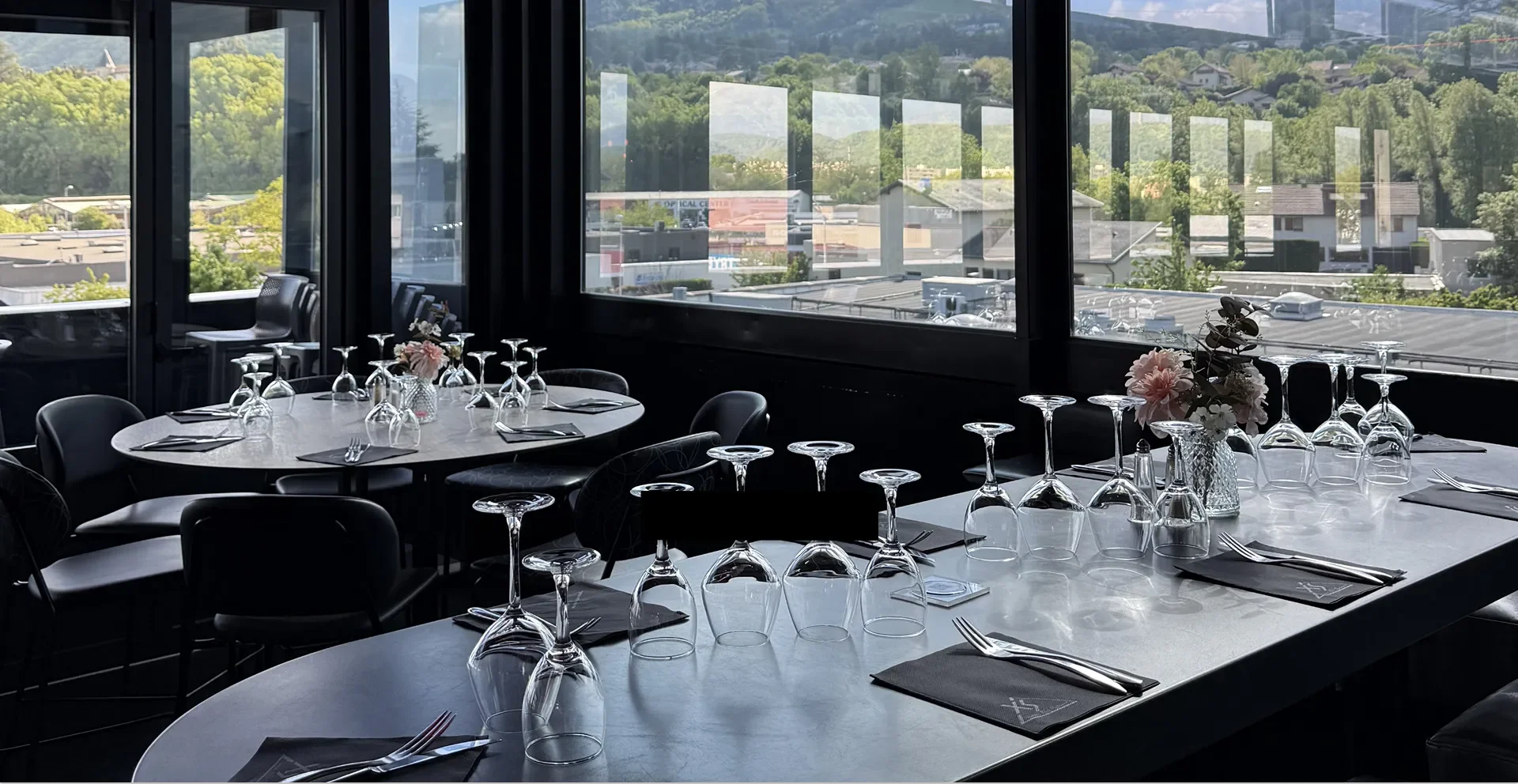 Salle élégante avec tables et verres dressés.