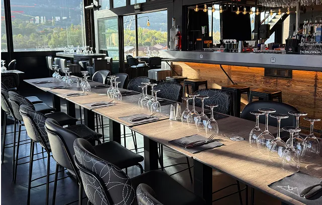Bar avec vue extérieure et tables dressées.