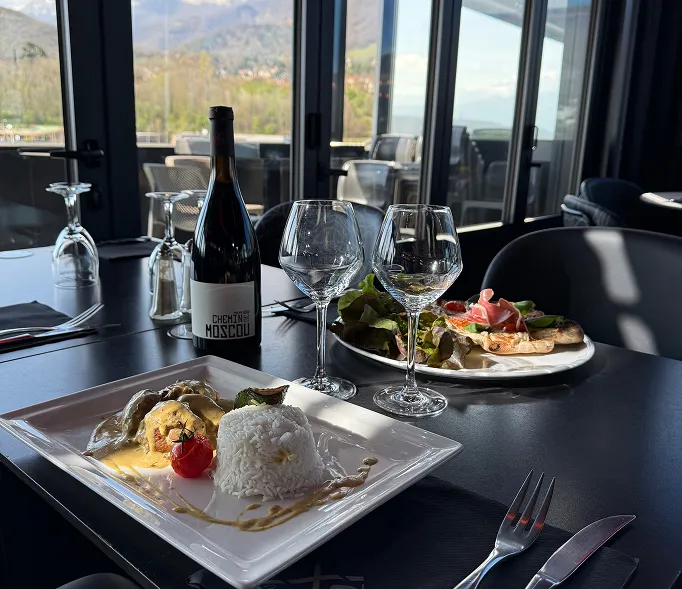Plat raffiné servi avec une bouteille de vin.